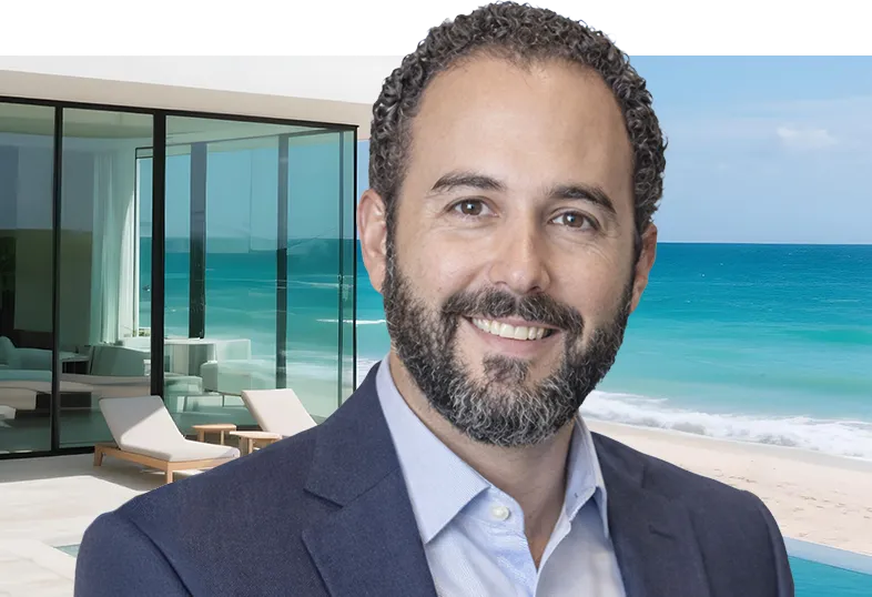 Professional headshot of Nathan, real estate and investment attorney, wearing a navy blazer against a beachfront luxury property background